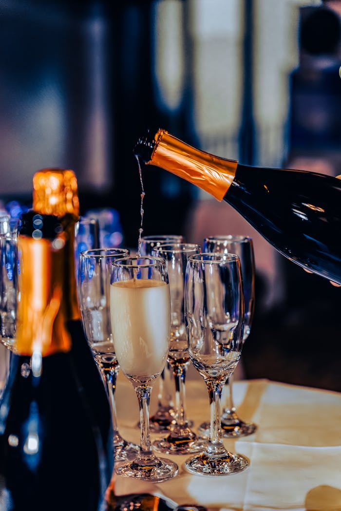 Luxurious champagne being poured into flute glasses at a festive gathering.