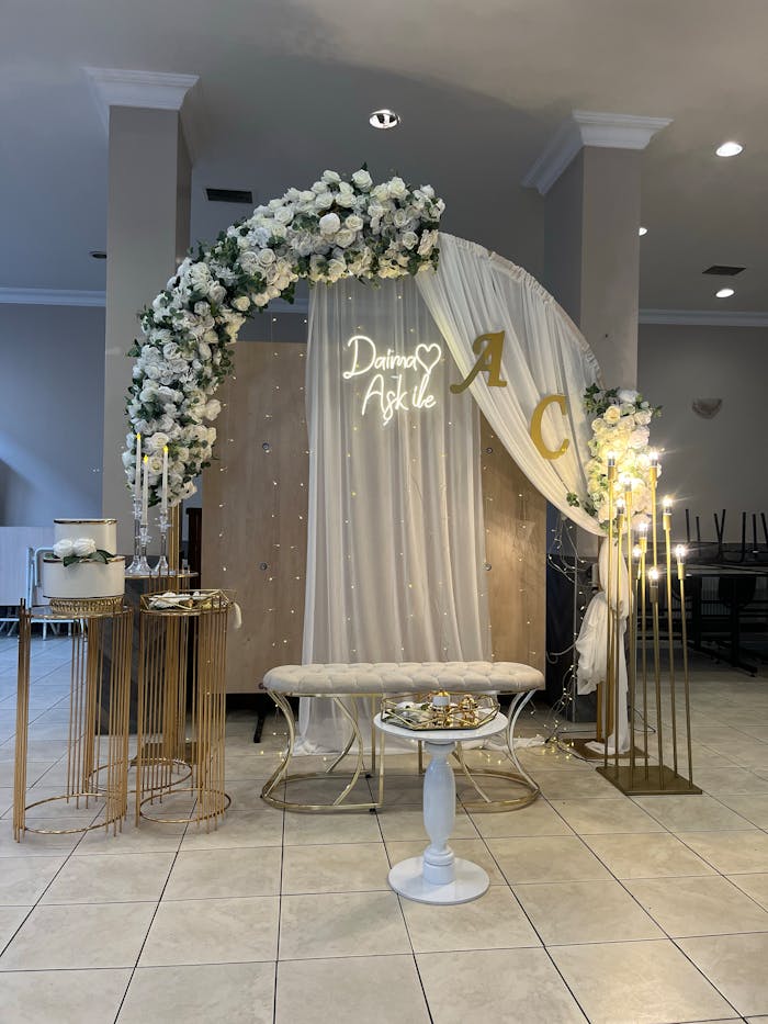 Beautifully decorated wedding arch with flowers and elegant details indoors.